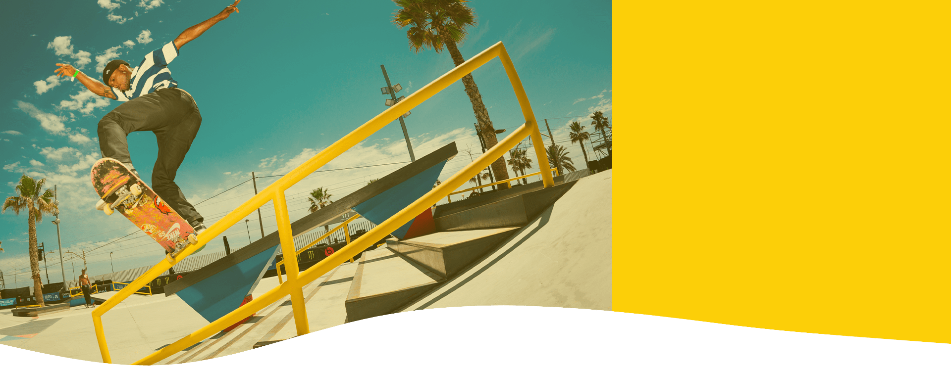 A skateboarder riding a yellow handrail