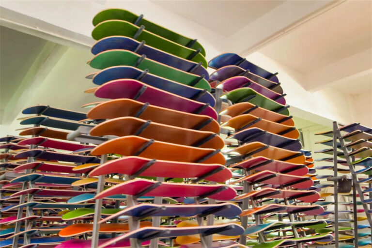 Colorful NAVA skateboard decks stacked in the factory
