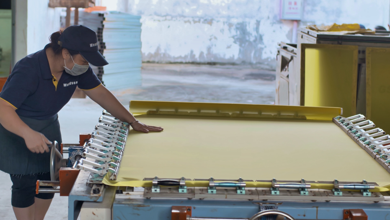 Worker preparing a screen printing frame in the workshop