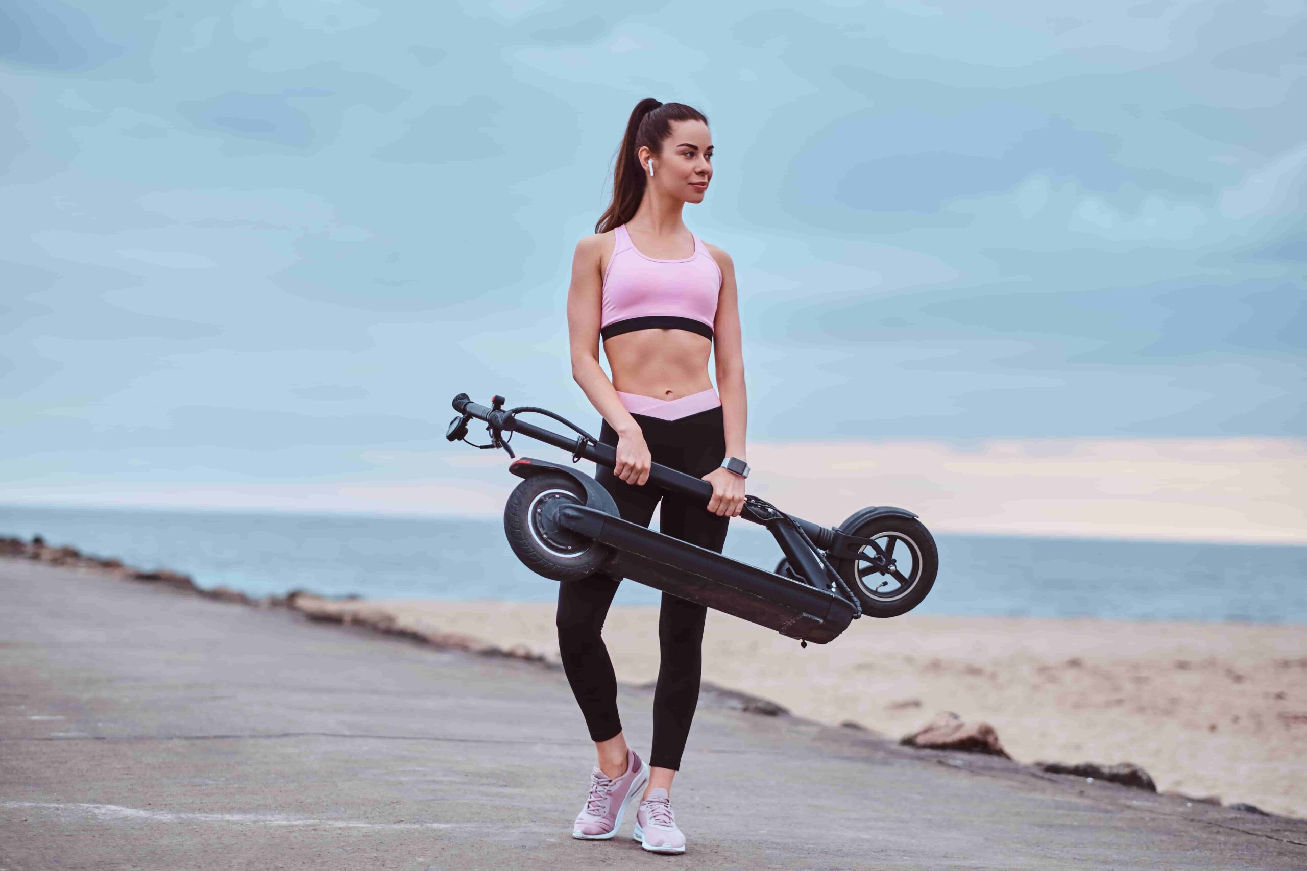 Person carrying a skateboard on a beach