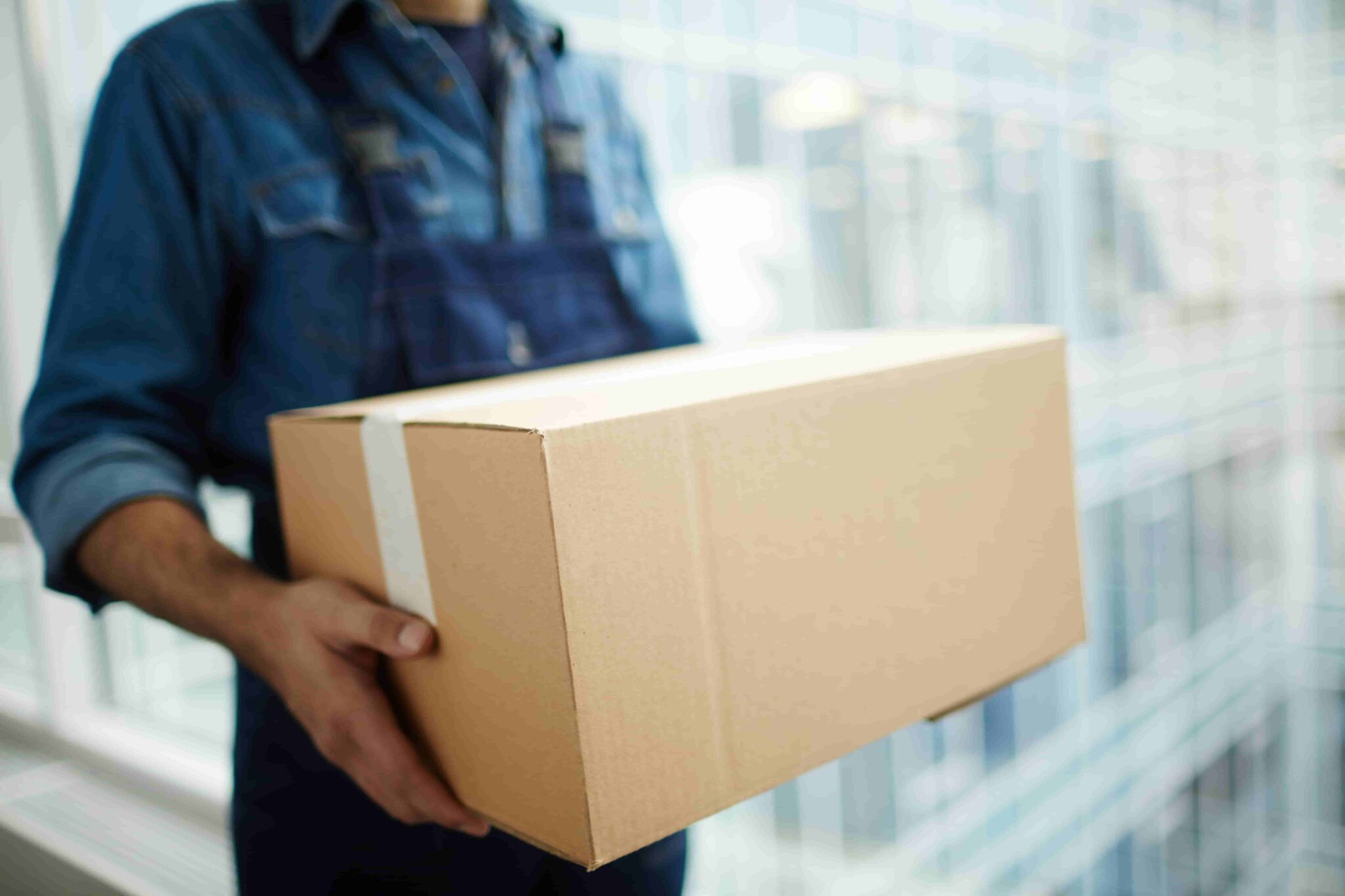 Person holding a cardboard shipping box