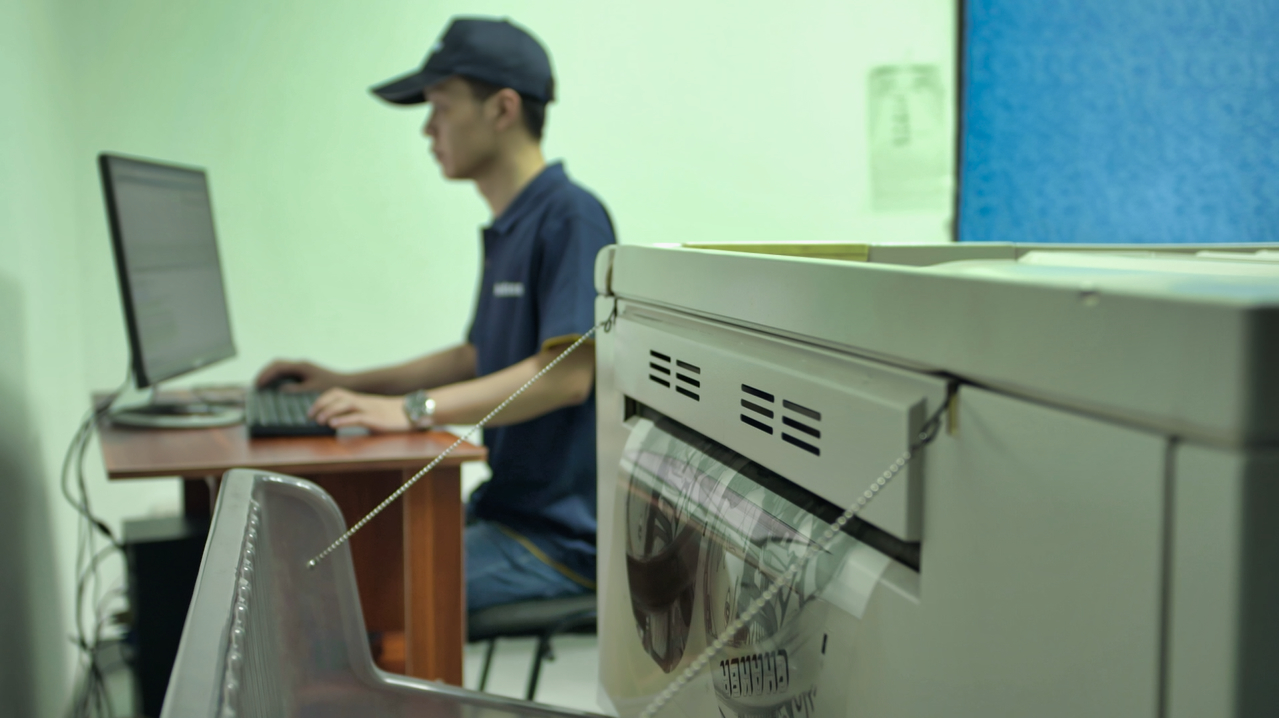 Worker operating a screen printing machine