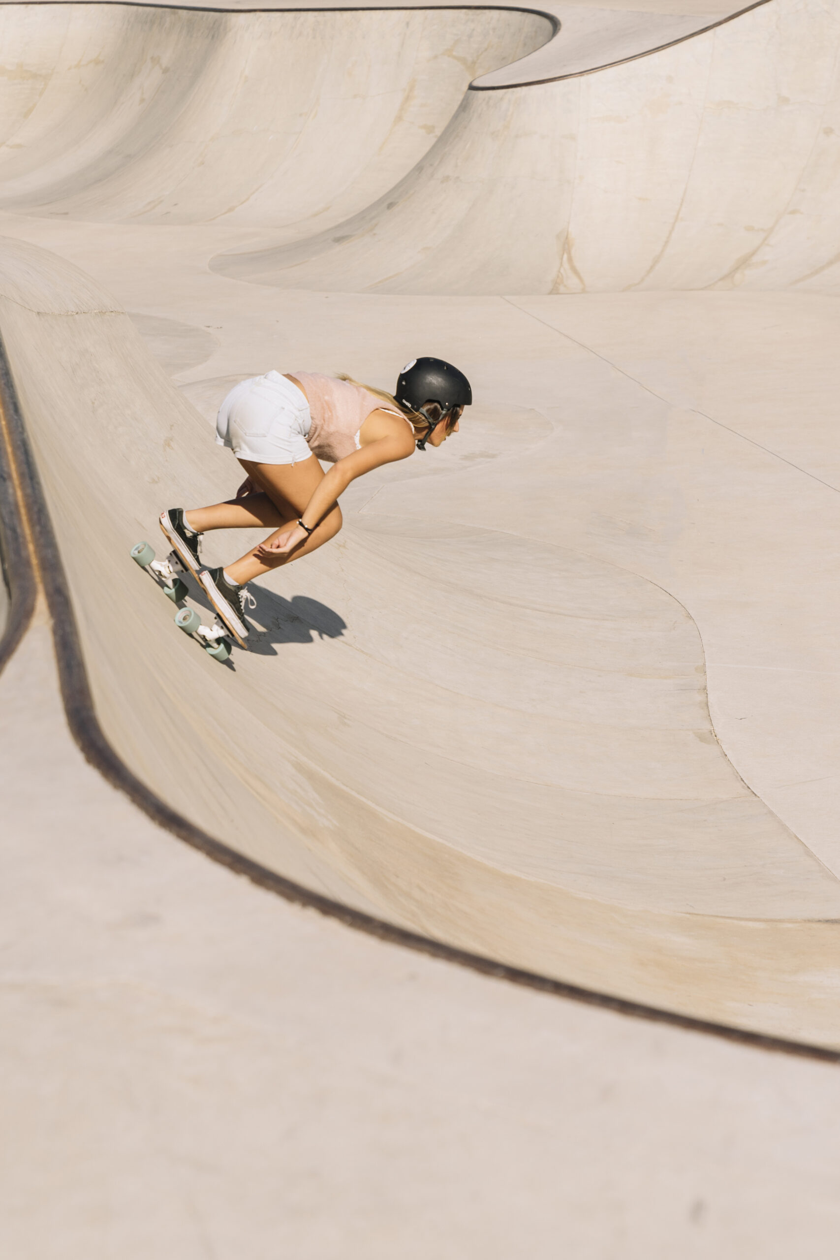 Skater wearing a helmet on a curved skatepark ramp