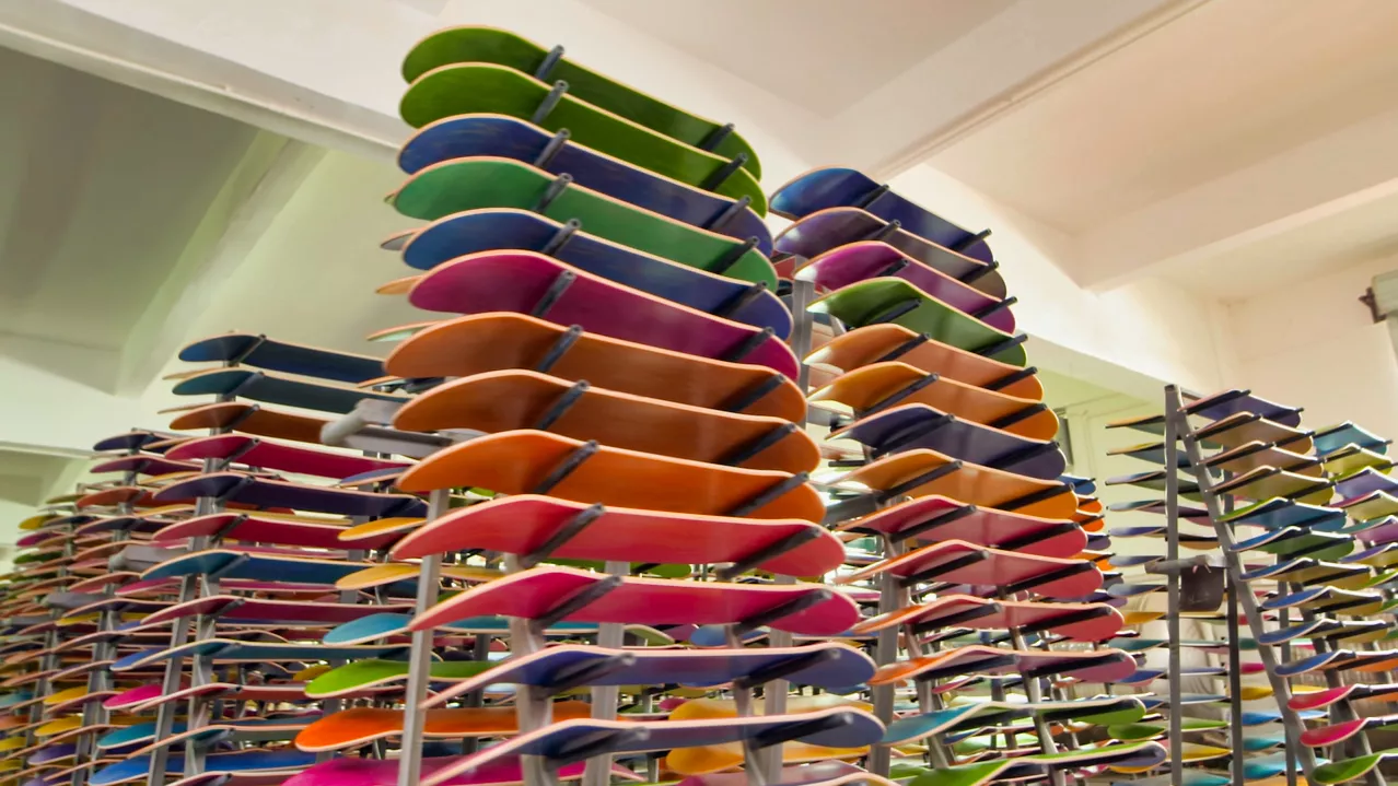 Finished skateboard decks arranged on drying racks
