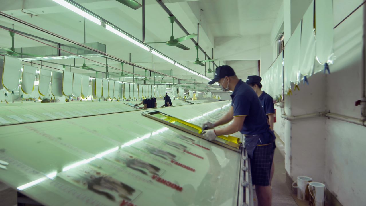 Worker checking a large screen printing frame