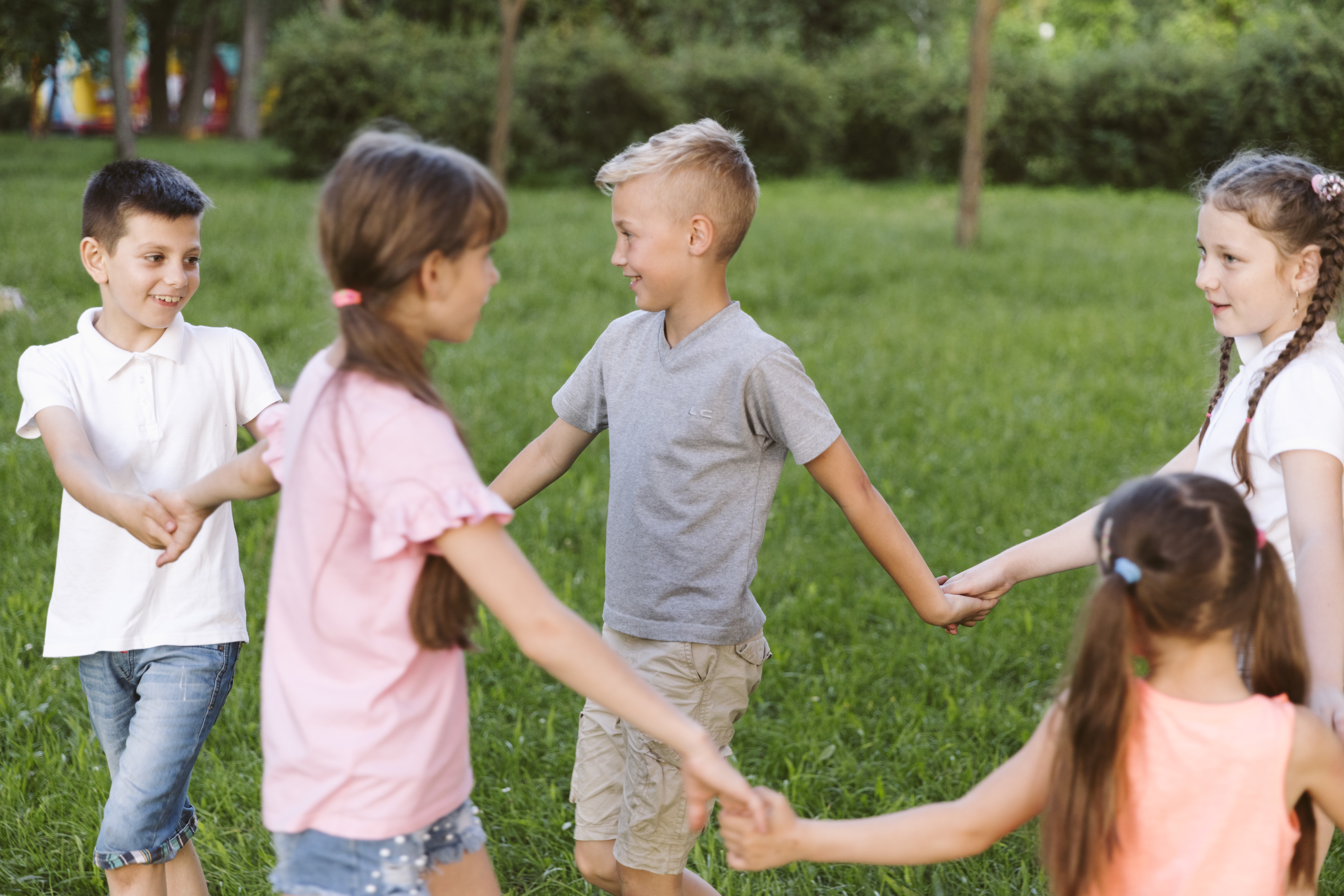 Children holding hands while playing outdoors